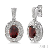 7x5 MM Oval Cut Garnet and 1/20 Ctw Round Cut Diamond Earrings in Sterling Silver