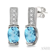 7x5 MM Oval Cut Blue Topaz and 1/50 Ctw Round Cut Diamond Earrings in Sterling Silver